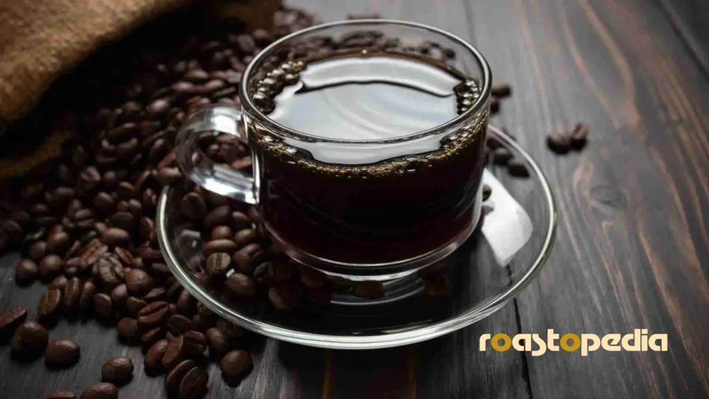 Dead eye coffee in a cup, on a wooden table, surrounded by coffee beans