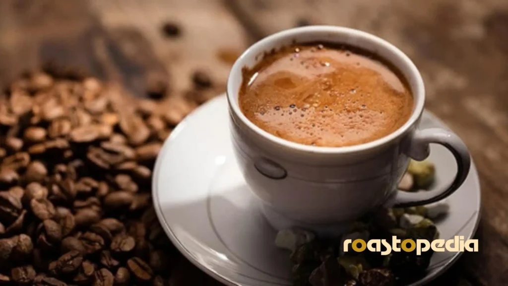 Dibek Kahvesi coffee in a cup surrounded by coffee beans